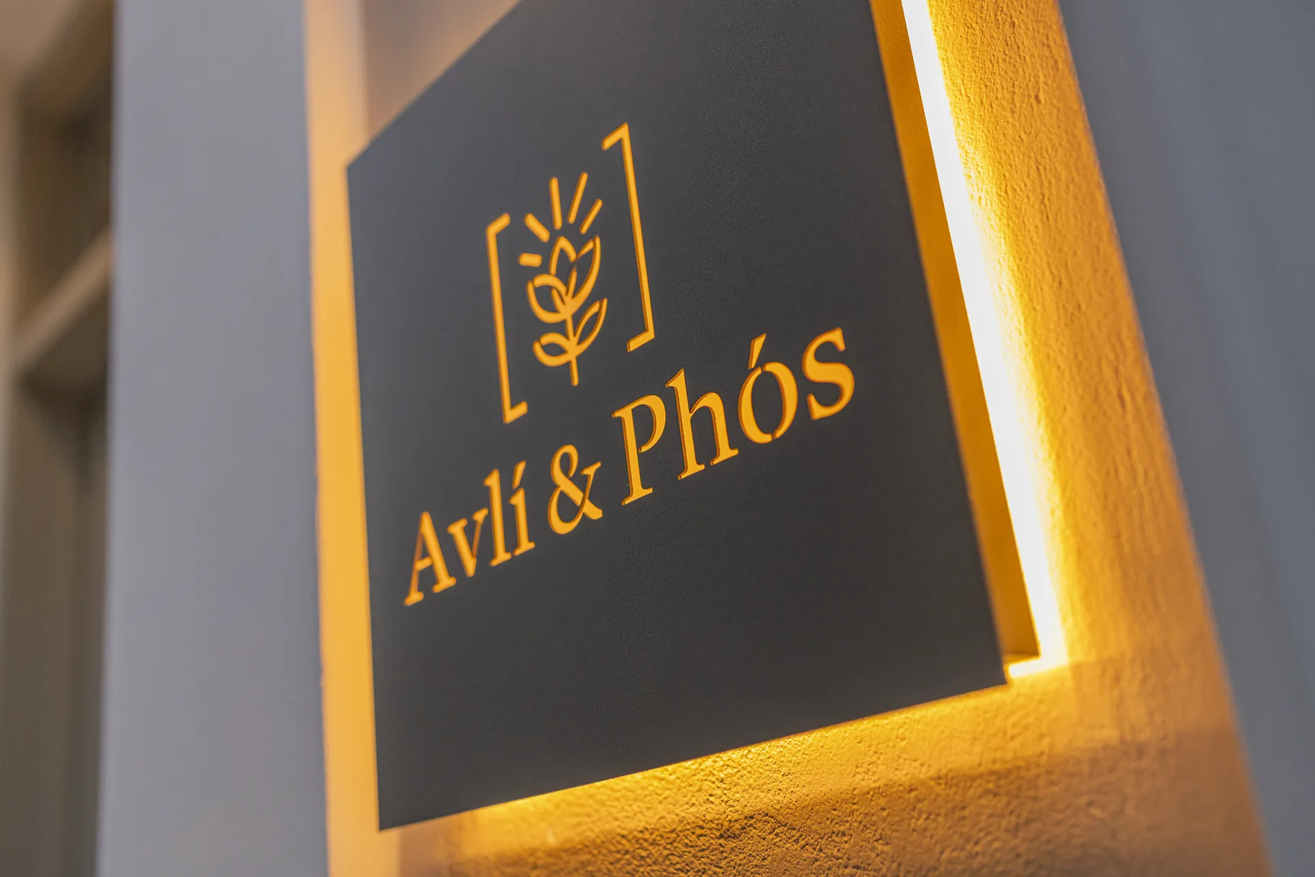Backlit Avlí & Phós sign at the entrance of the house