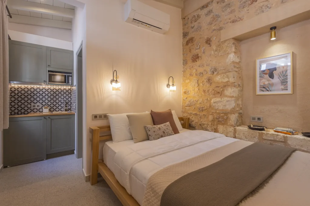 The open layout of the Classic Studio — bed, kitchenette and stone wall