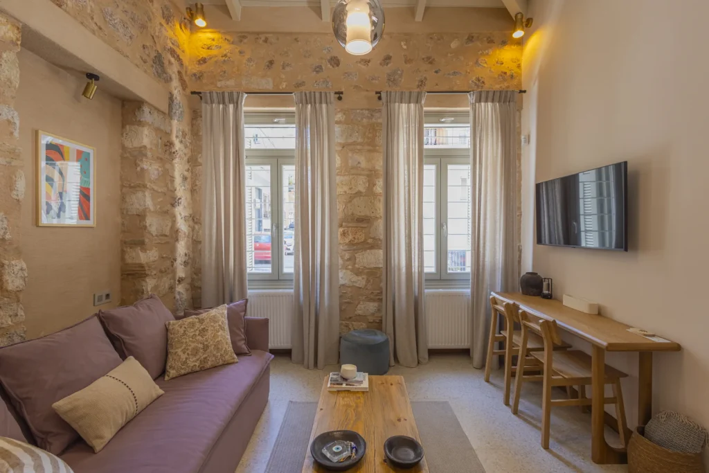 Junior Suite living room with a mauve sofa and tall street-facing windows