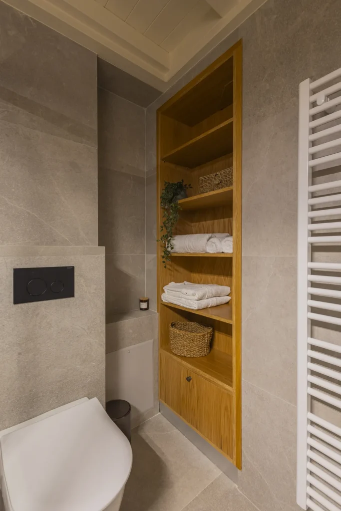 Bathroom detail in the Junior Suite with recessed wooden shelving and towels