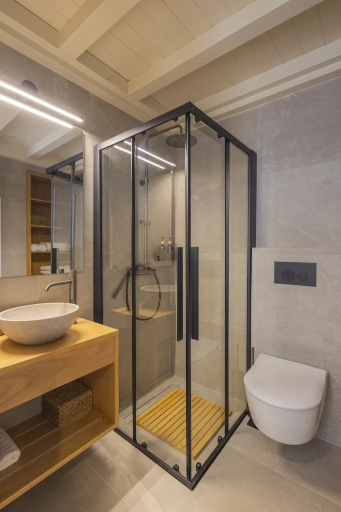 Junior Suite bathroom with a corner rainfall shower and timber vanity