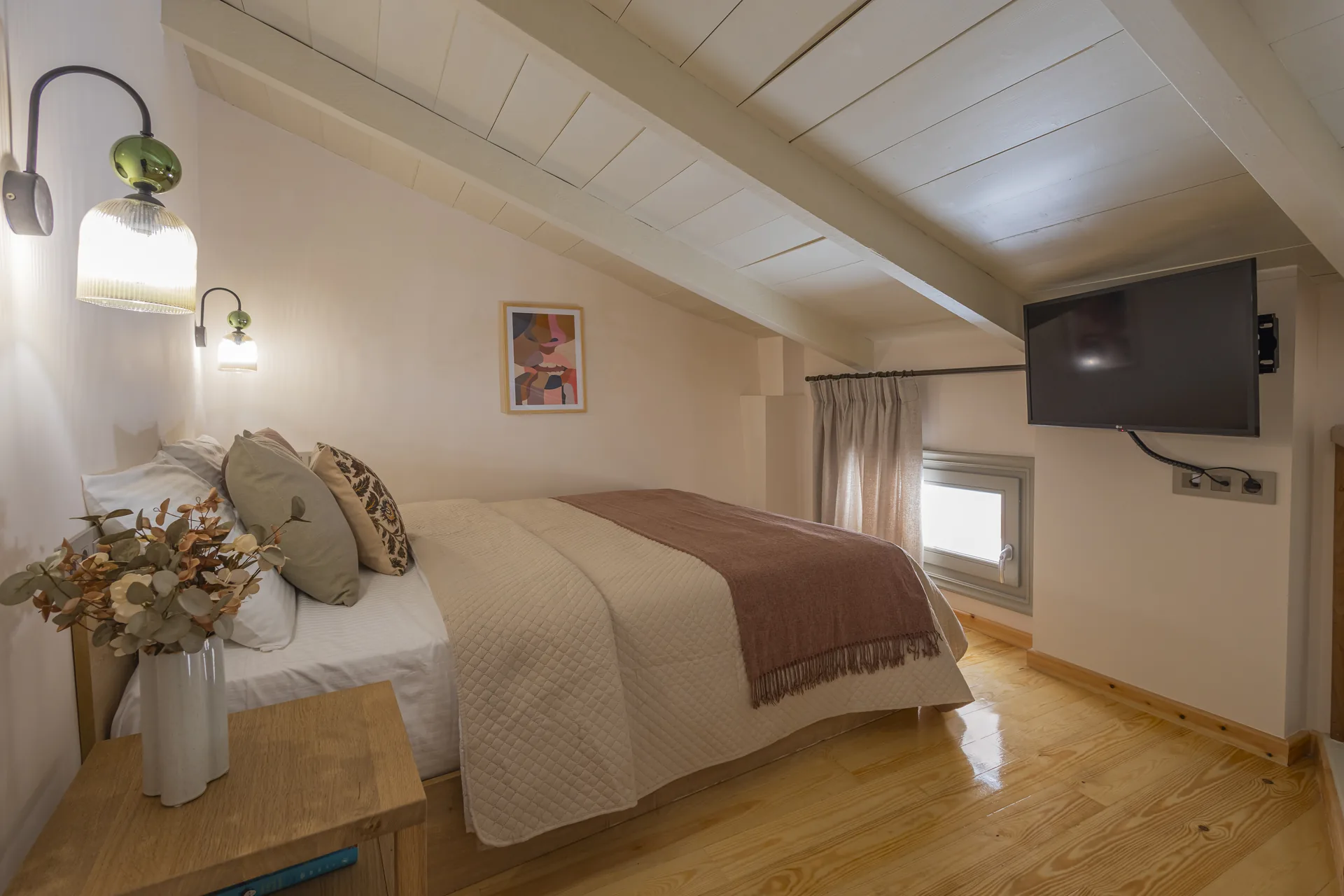 Loft bedroom with a sloped timber-plank ceiling at Avlí & Phós, Thissio